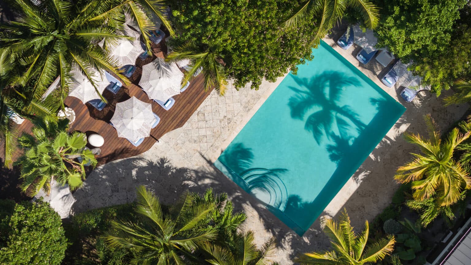 Aerial still of Oasis at Grace Bay, palms and loungers around the water